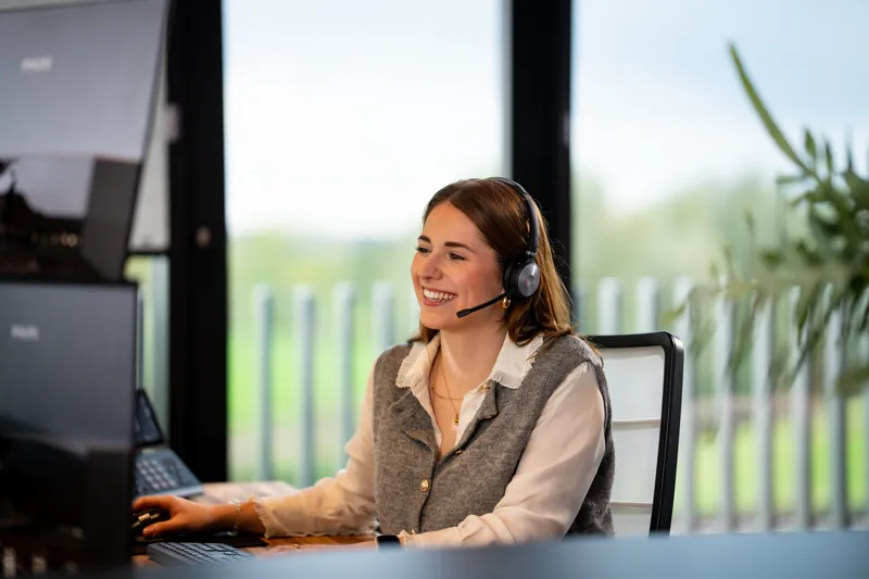 Collega van Cebec met headset aan de servicedesk